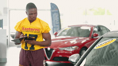 Man In Yellow Shirt Easterns Automotive Group Writing On Clipboard GIF