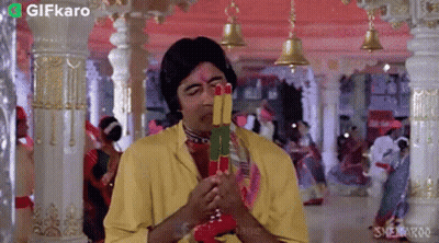 Man In Yellow Shirt Holding Colorful Sticks GIF