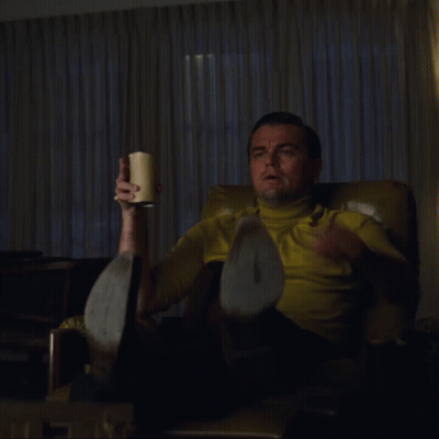 Man In Yellow Shirt Holding Cup And Pointing GIF