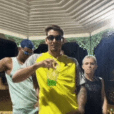 Man In Yellow Shirt Holding Drink GIF