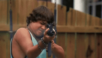 Man In Yellow Shirt Holding Gun Next To Boy In Blue Shirt GIF