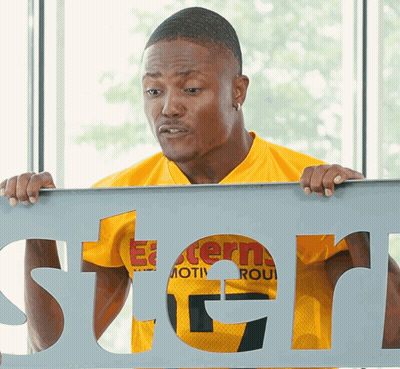 Man In Yellow Shirt Holding Stern Sign GIF