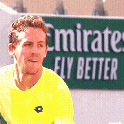 Man In Yellow Shirt In Front Of Emirates Fly Better Sign GIF