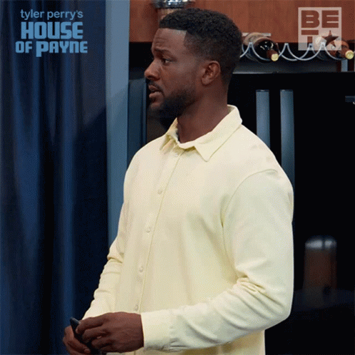 Man In Yellow Shirt In Front Of House Of Payne Sign GIF
