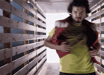 Man In Yellow Shirt In Wooden Hallway GIF