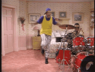 Man In Yellow Shirt Jumping In Front Of Drum Set GIF