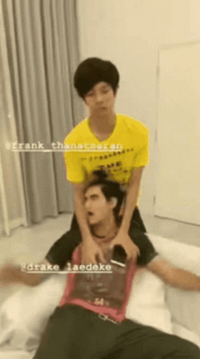Man in Yellow Shirt Laying on Another Man's Back on Bed