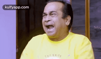 Man In Yellow Shirt Making Funny Face With Mouth Open GIF