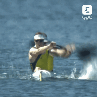 Man In Yellow Shirt Paddling Kayak With Olympics Logo GIF
