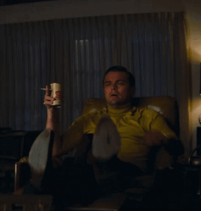 Man In Yellow Shirt Pointing While Sitting GIF