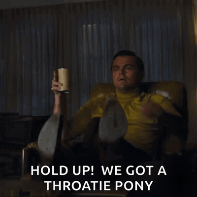 Man In Yellow Shirt Sitting Holding Coffee And Pointing GIF
