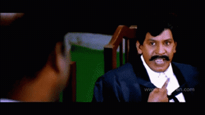 Man In Yellow Shirt Standing Before Suited Men GIF