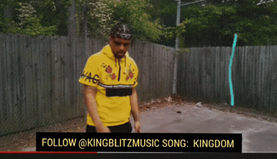 Man In Yellow Shirt Standing In Front Of Fence GIF
