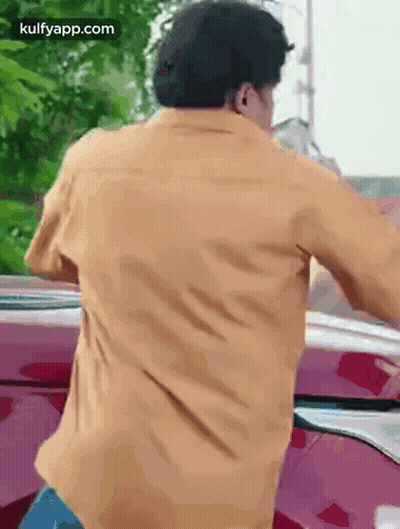 Man In Yellow Shirt Standing In Front Of Red Car GIF