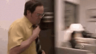Man In Yellow Shirt Talking On Cell Phone By Fridge GIF