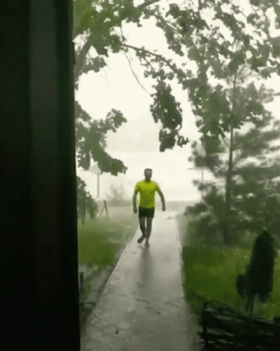 Man In Yellow Shirt Walking In Rain GIF