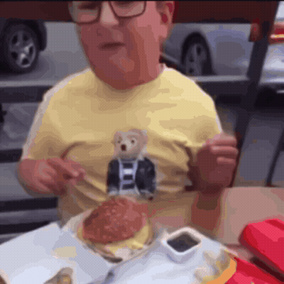 Man In Yellow Shirt With Teddy Bear Eating Hamburger GIF