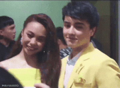 Man In Yellow Suit Next To Woman In Yellow Dress GIF