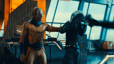 Man In Yellow Superhero Suit Next To Man GIF