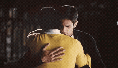 Man In Yellow Sweater Hugging Man In Black Jacket GIF
