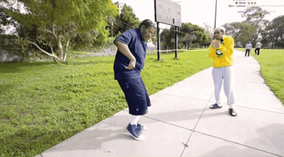 Man In Yellow Sweatshirt With Letter C Next To Woman In Blue GIF