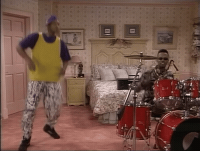 Man In Yellow Vest Dancing Next To Drummer GIF
