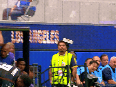 Man In Yellow Vest In Front Of Los Angeles Screen GIF
