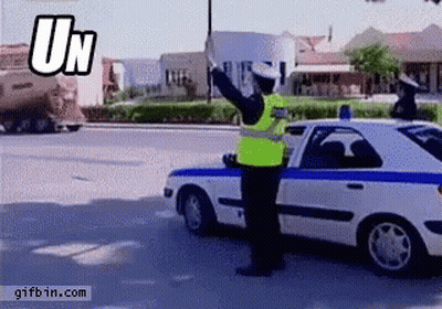 Man In Yellow Vest In Front Of Police Car Saying UN GIF