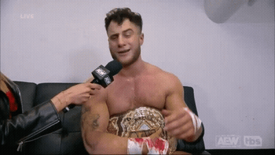 Man Interviewed By Woman While Wearing Wrestling Belt GIF