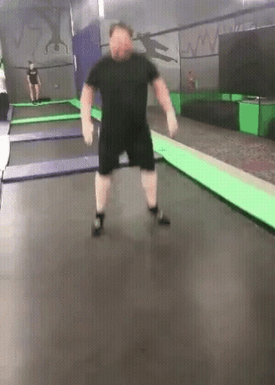 Man Jumping on Trampoline with Another Watching