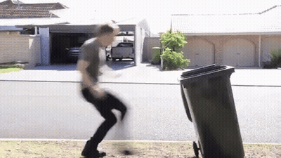 Man Jumping Over Trash Can In Front Of House GIF