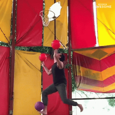 Man Jumping Through Basketball Hoop Holding Two Balls Saying Awesome GIF