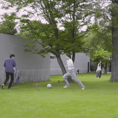 Man Kicking Soccer Ball While Another Watches GIF