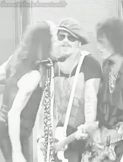 Man Kissing Another Man On Cheek Playing Guitar GIF
