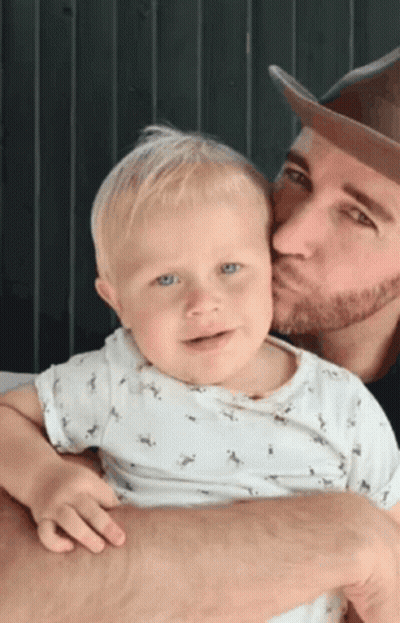 Man Kissing Baby On Cheek GIF