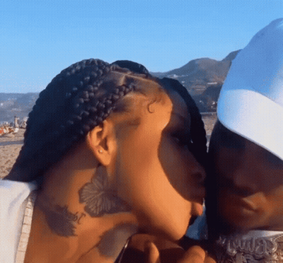 Man Kissing Woman On Cheek On Beach GIF