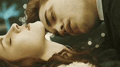 Man Kissing Woman On Forehead Laying Down GIF