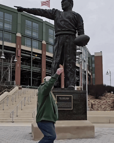 Man Kneeling Before Football Statue GIF