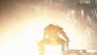 Man Kneeling Before Large Fire GIF