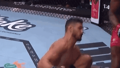 Man Kneeling In Boxing Ring With Another Man Behind GIF