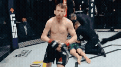 Man Kneeling In Boxing Ring With Referee GIF