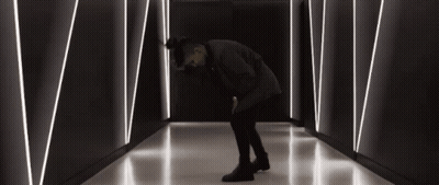 Man Kneeling In Dark Hallway With Lines GIF