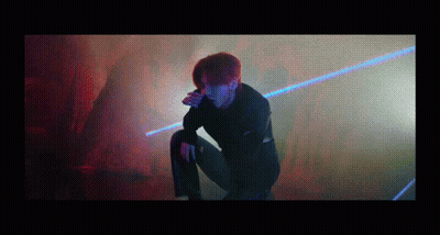 Man Kneeling In Dark Room With Laser GIF