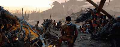 Man Kneeling In Front Of Group In Destroyed Area GIF