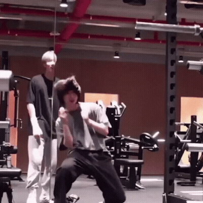 Man Kneeling In Gym With Another Man Standing Behind GIF