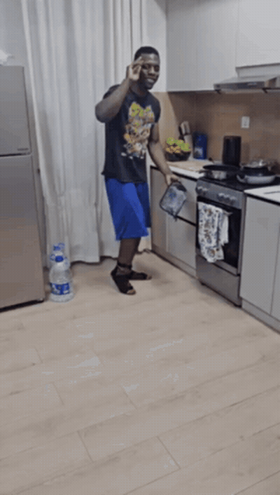 Man Kneeling In Kitchen With Aquafina Water GIF