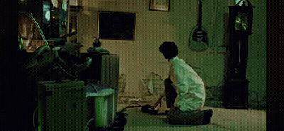 Man Kneeling In Room With Clock And Guitar GIF