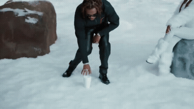 Man Kneeling In Snow Holding Cup GIF