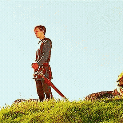 Man Kneeling Next To Lion With Sword GIF