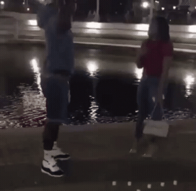 Man Kneeling Proposing To Woman In Front Of Fountain GIF